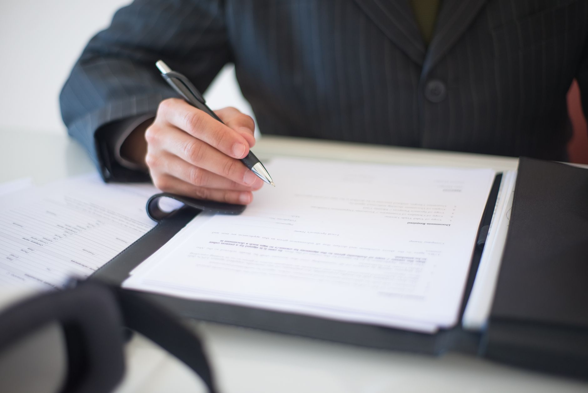 Business professional reviewing compliance documentation at a desk