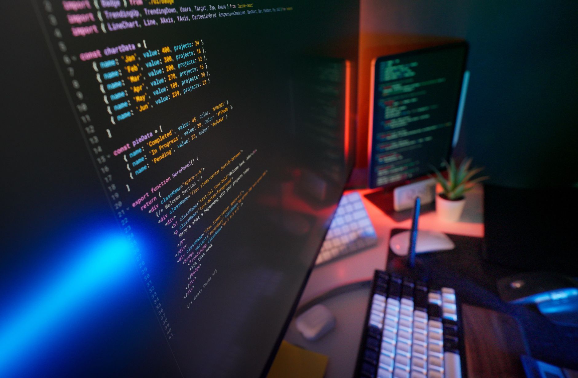 Developer working at a computer with multiple screens showing code and UI components