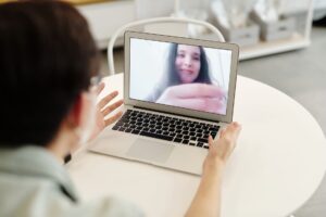 Person on a video call using a laptop, representing remote meeting technology