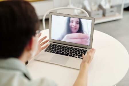 Person on a video call using a laptop, representing remote meeting technology