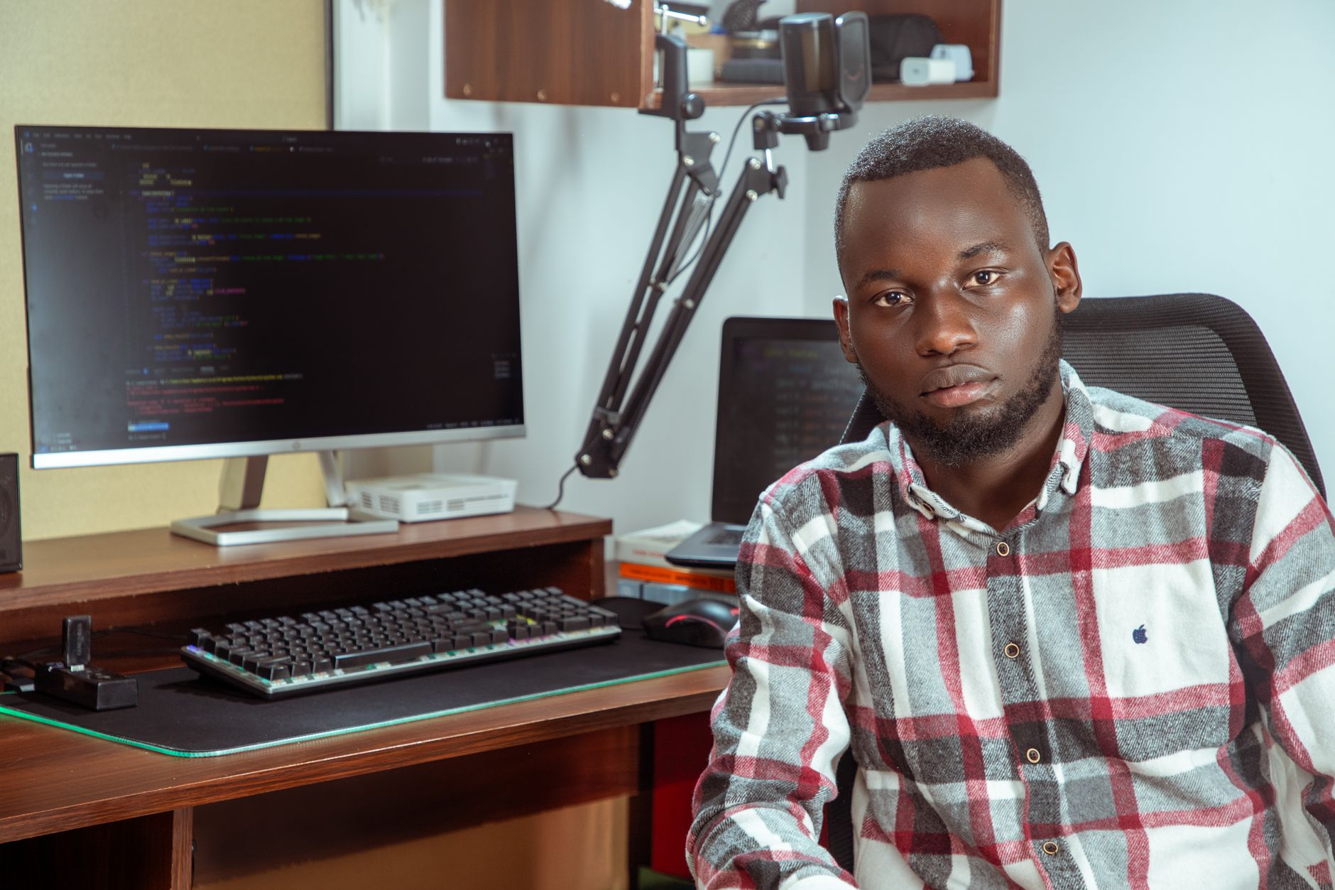 Software developer working at a dual-monitor desk setup with code on screen