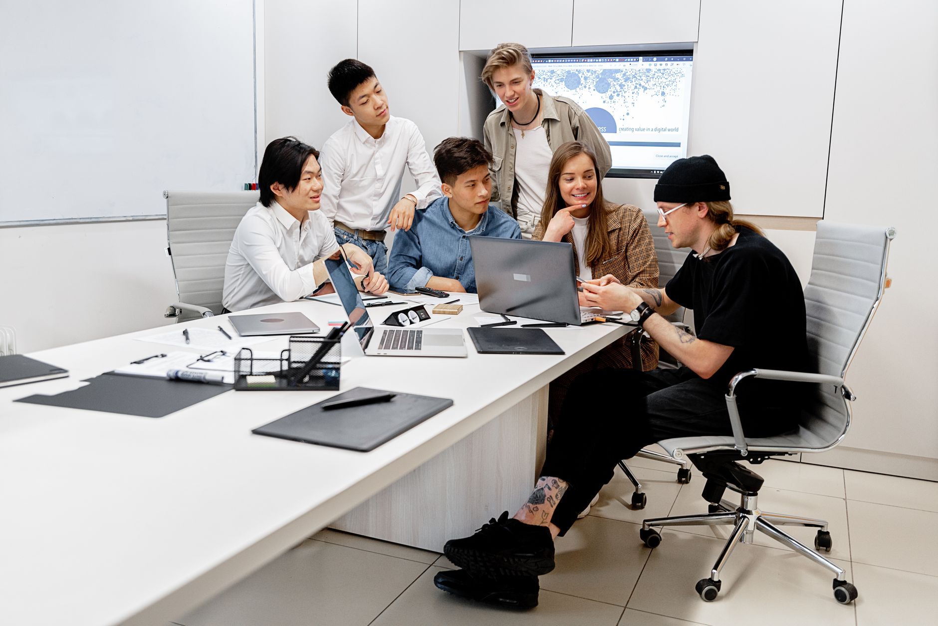 A small startup team collaborating around a table with laptops and notebooks