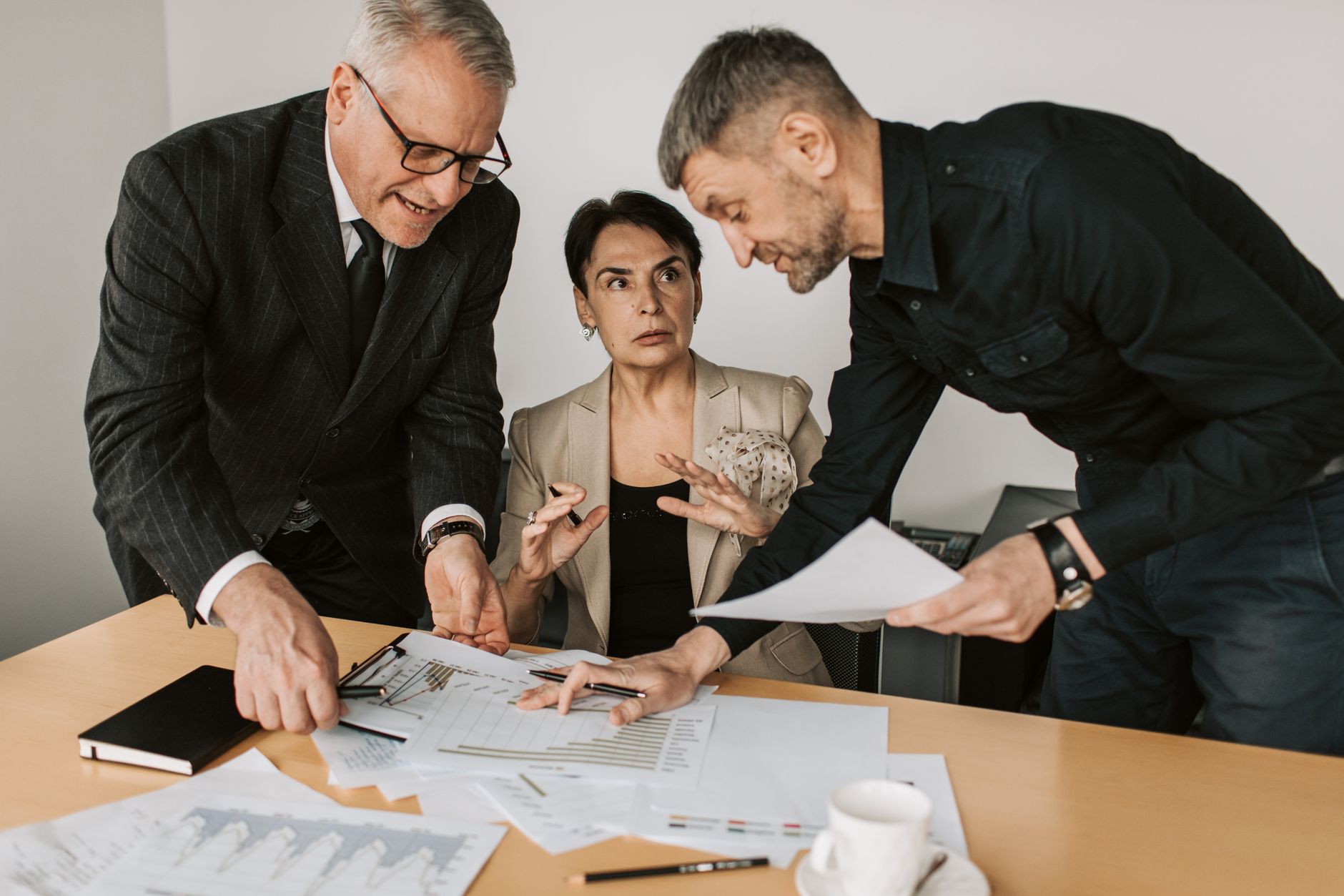 Business professionals reviewing presentation materials on a laptop during a team meeting
