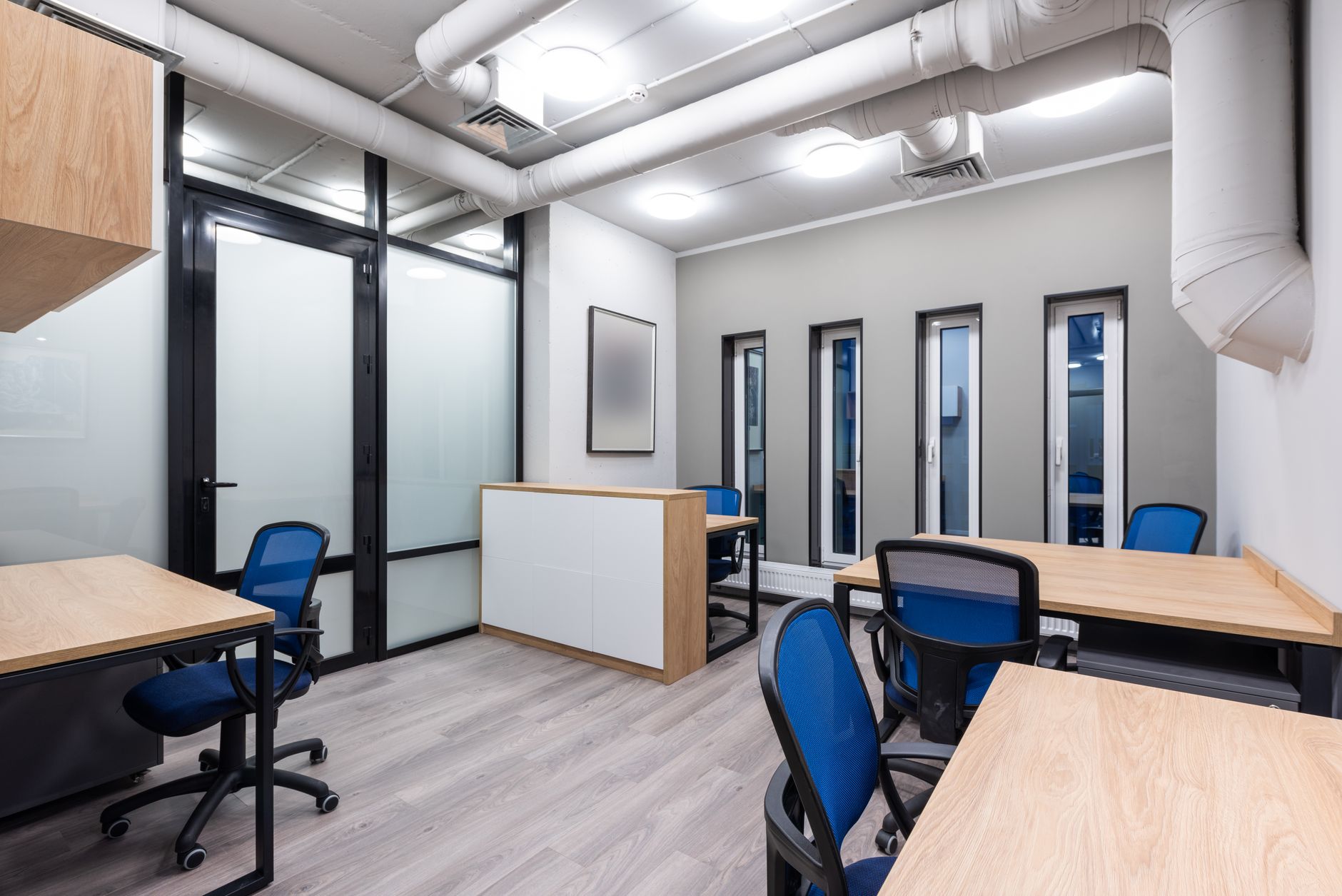 Open-plan startup office with engineers working at standing desks