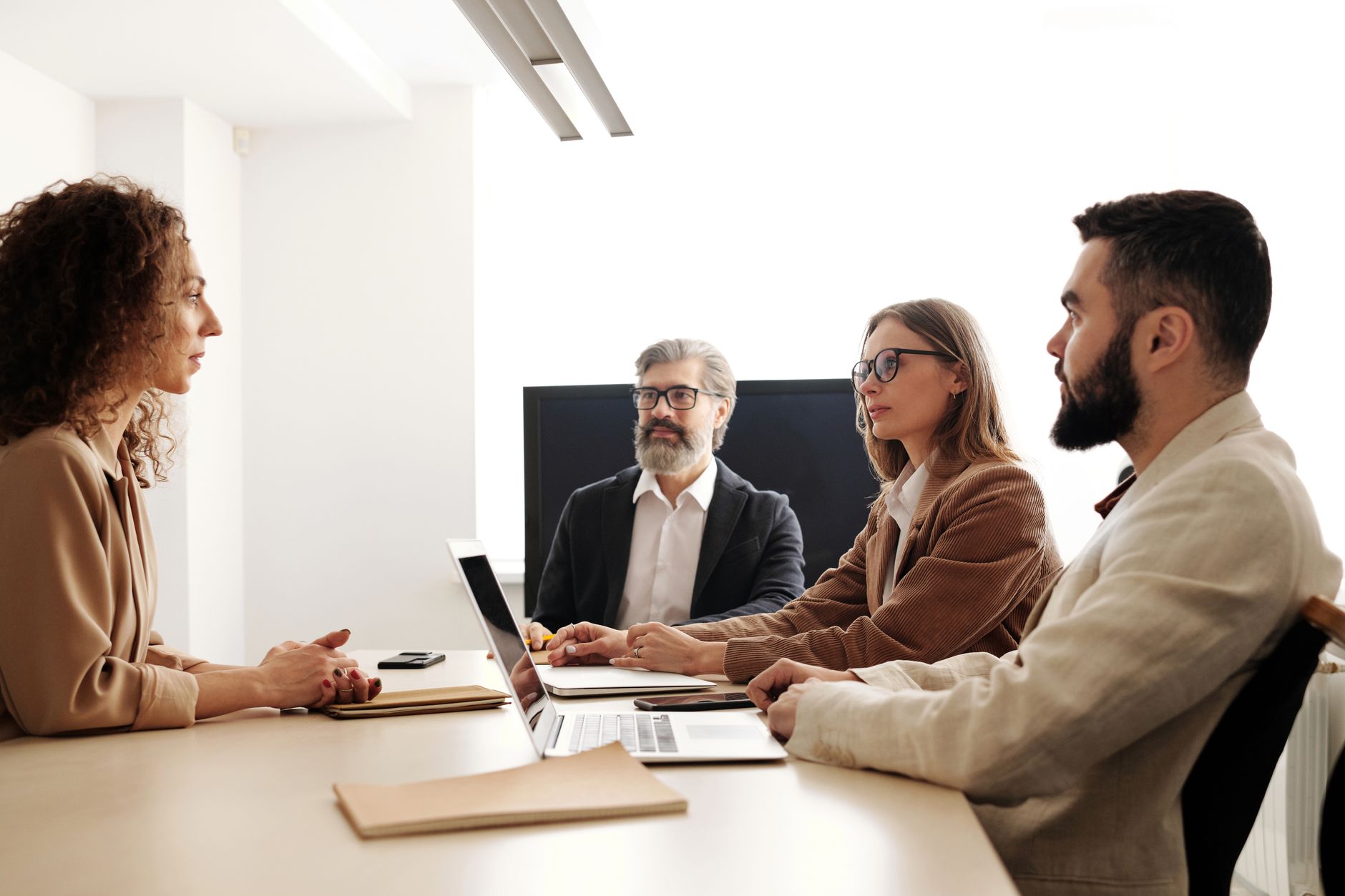 A small recruiting team reviewing candidates together in a conference room