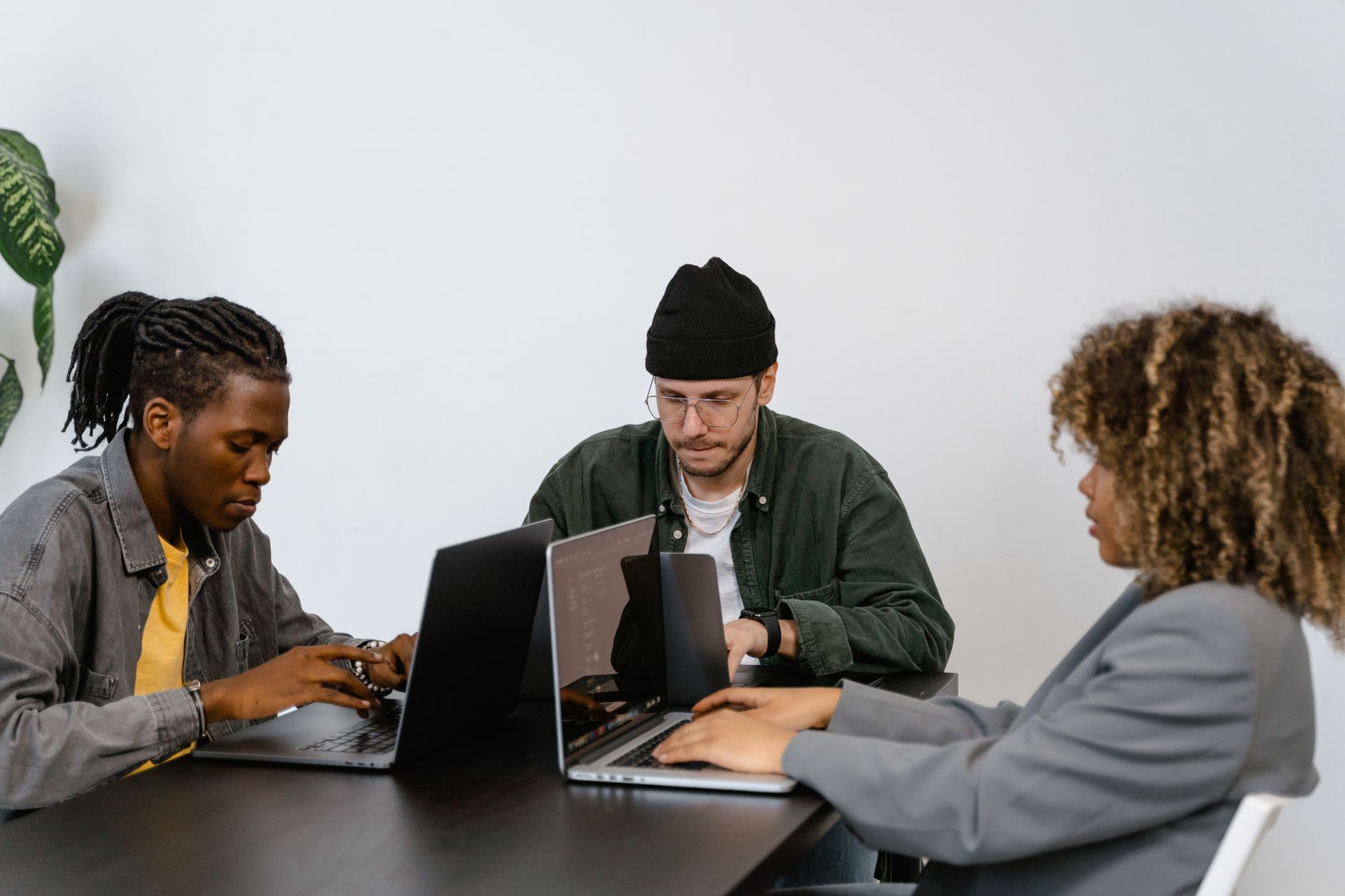 Startup team collaborating around a workspace with digital tools and screens