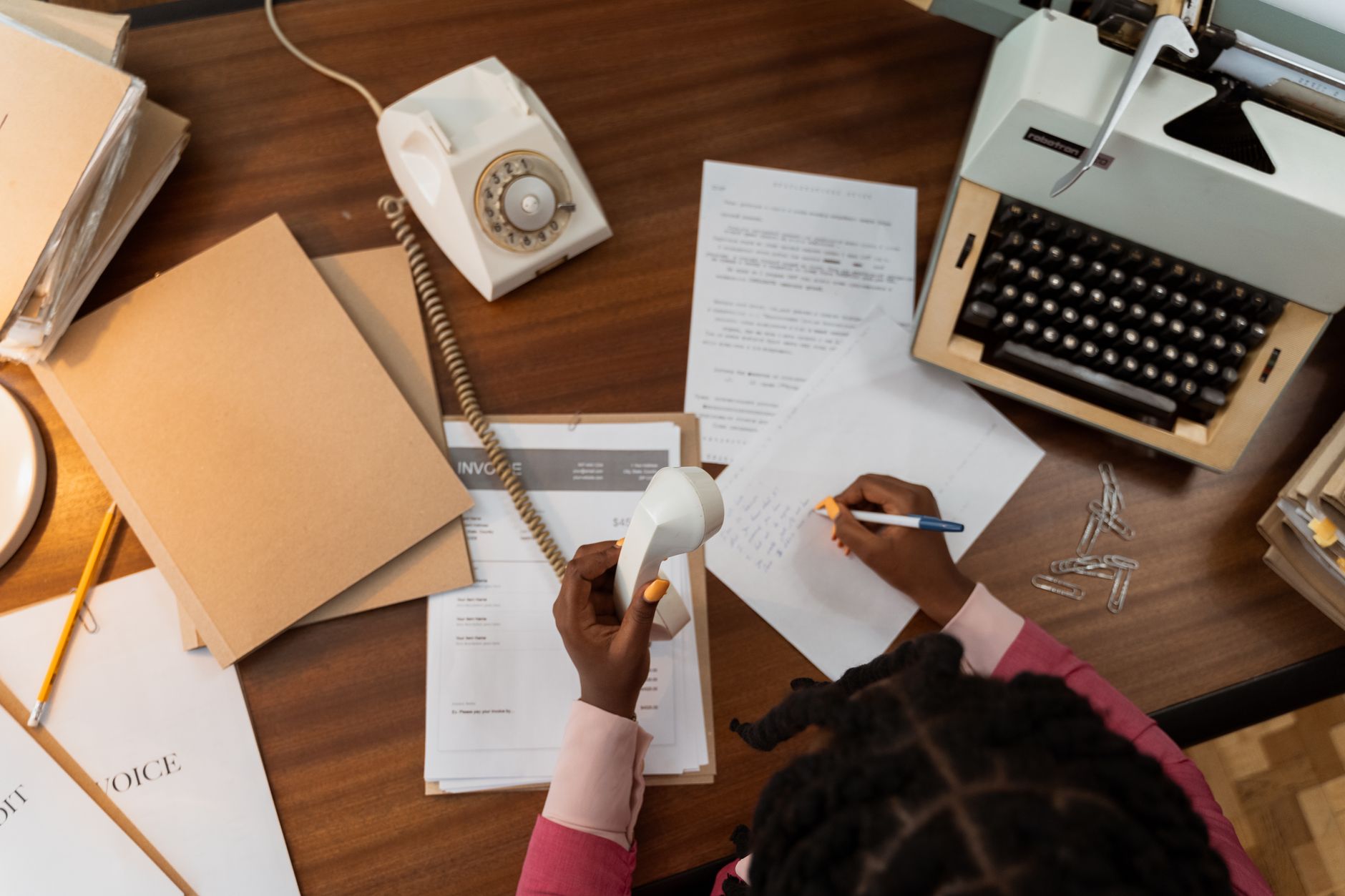 A business professional reviewing invoices and financial documents at a desk