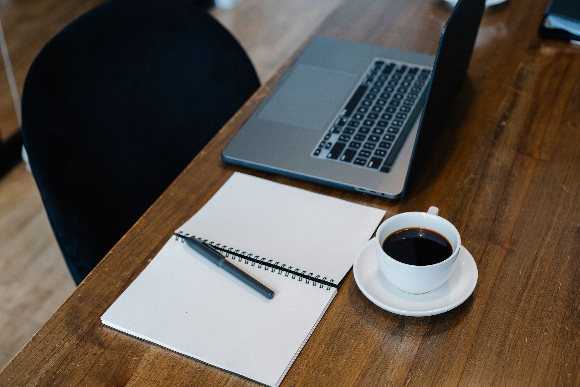 Clean desk workspace with laptop and notebook representing focused productivity tools