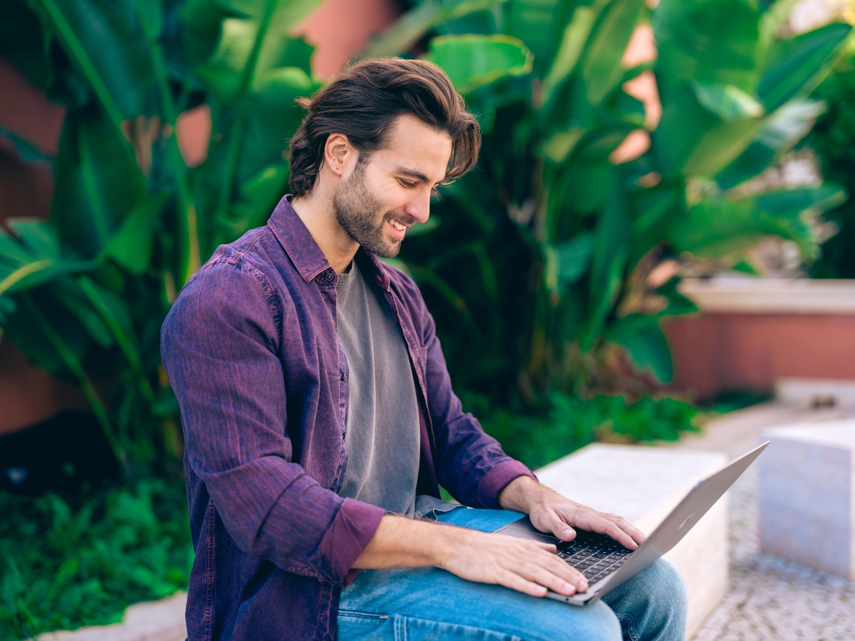 Person working remotely on a laptop with global map in background