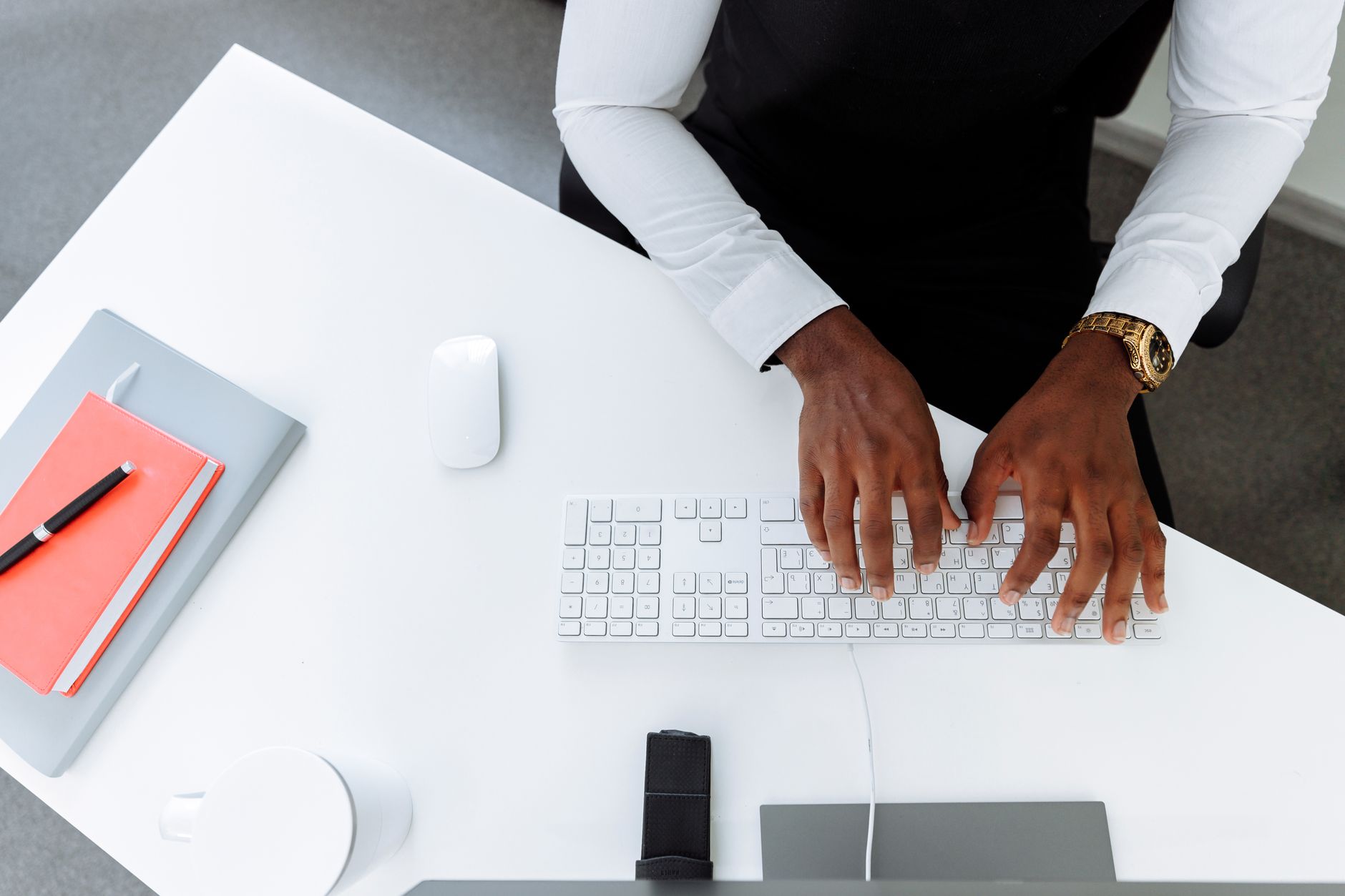 A professional typing on a laptop in a modern office setting