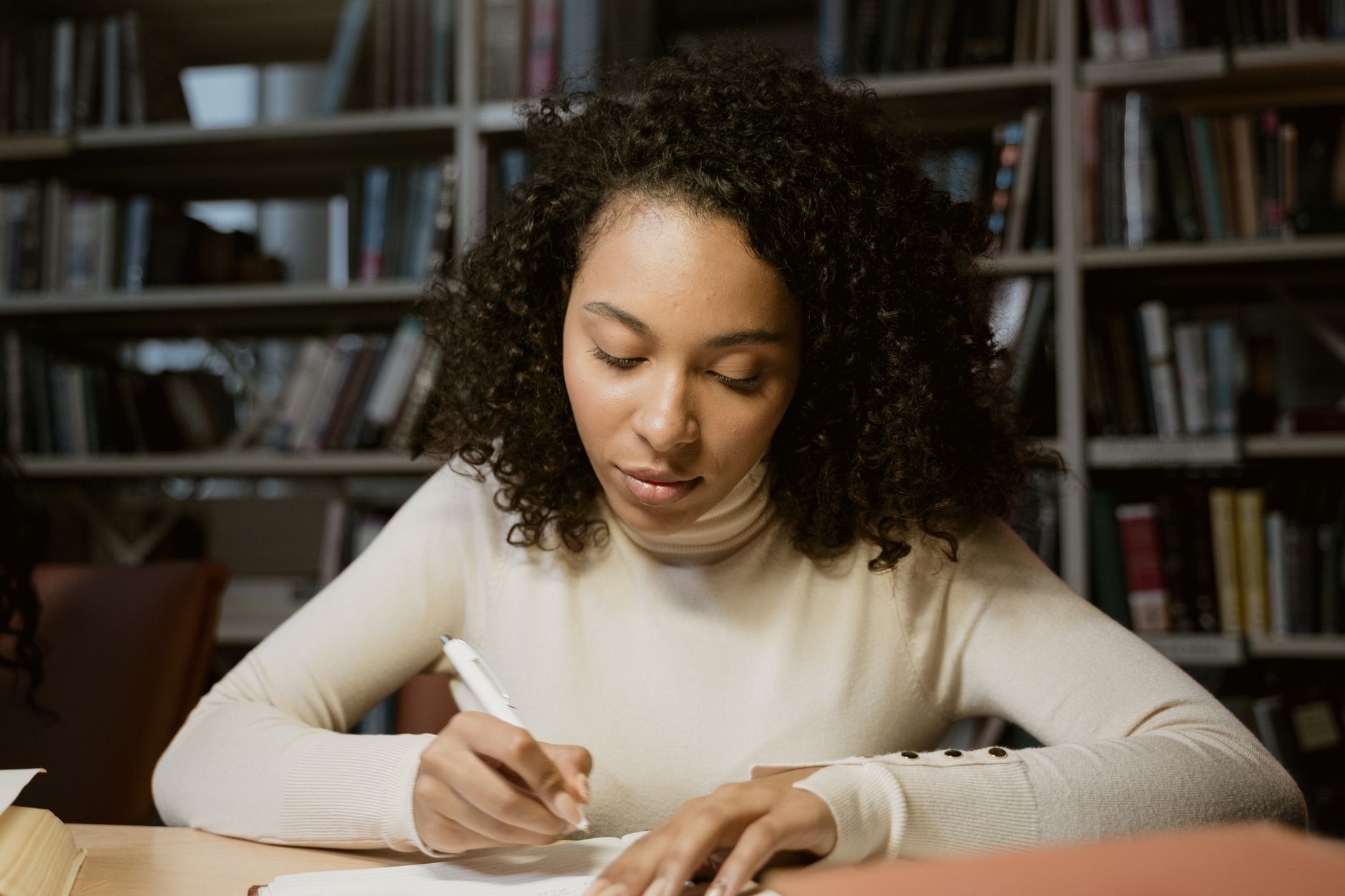 Young woman focused on studying with headphones and a notebook